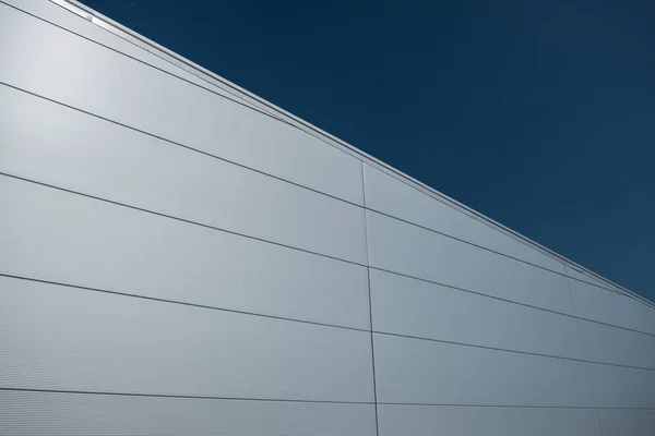 Modern building facade covered with steel sandwich panels in silver color