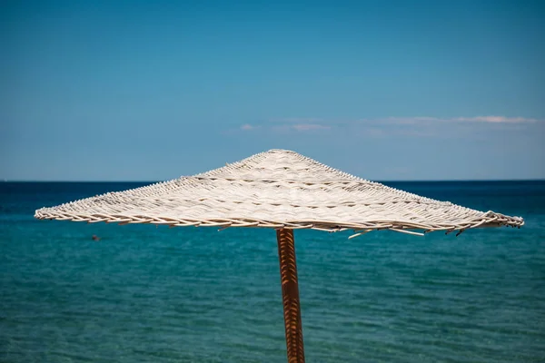 Strohbedeckter Sonnenschirm Strand Mit Türkisfarbenem Wasser Hintergrund — Stockfoto