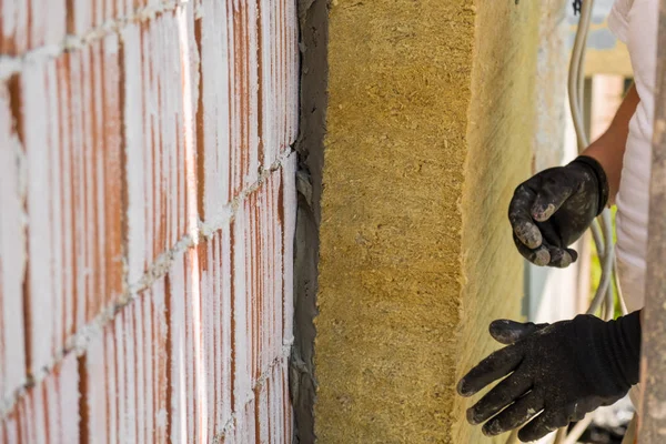 İşçi ön cepheye kaya yünü panelleri yerleştiriyor