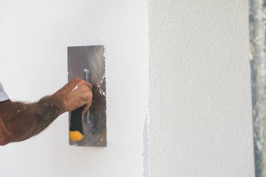 Boyacı evin ön cephesine yeni boya sürmüş.