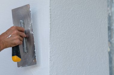 Boyacı evin ön cephesine yeni boya sürmüş.