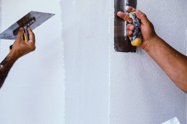 Boyacı evin ön cephesine yeni boya sürmüş.