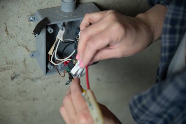 Kadın elektrikçi kontrolü ya da elektrik prizi denetimi. İş gücü kavramında çeşitlilik.