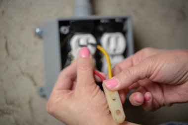 Kadın elektrikçi kontrolü ya da elektrik prizi denetimi. İş gücü kavramında çeşitlilik.