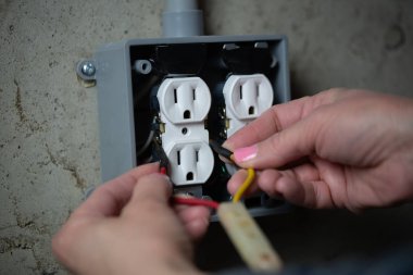 Bir prizi tamir eden Kadın Elektrik