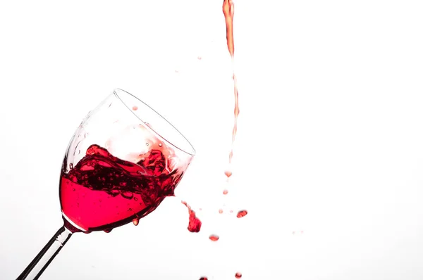 Despejando vinho tinto em um copo inclinado — Fotografia de Stock