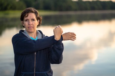 Yaşlı kadın bir nehir tarafından sabahın erken saatlerinde uzanan