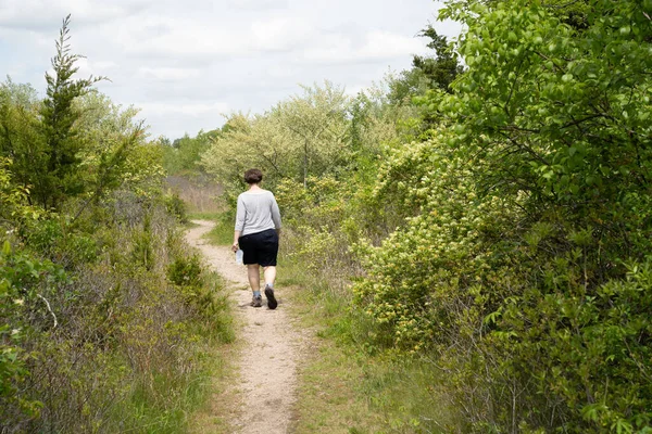 Woman walking in the woods on a trail
