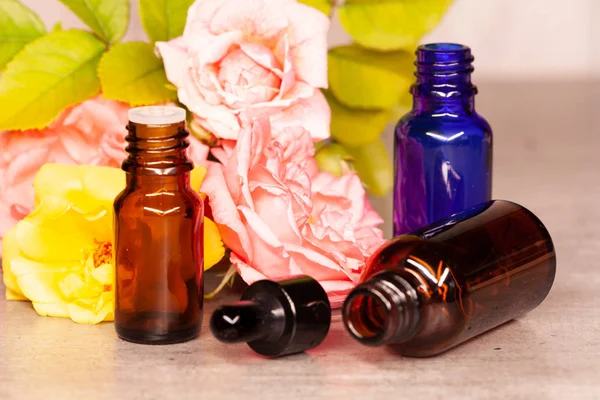 Rose flowers and bottles of essential oils for aromatherapy