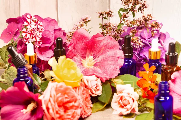 flowers and bottles of essential oils for aromatherapy