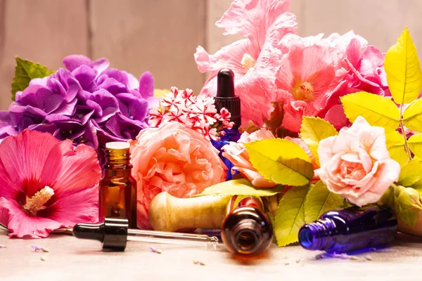 flowers and bottles of essential oils for aromatherapy