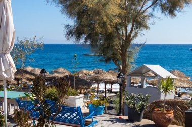 plaj şemsiye ve şezlonglar Santorini deniz ile
