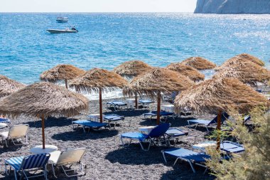 plaj şemsiye ve şezlonglar Santorini deniz ile