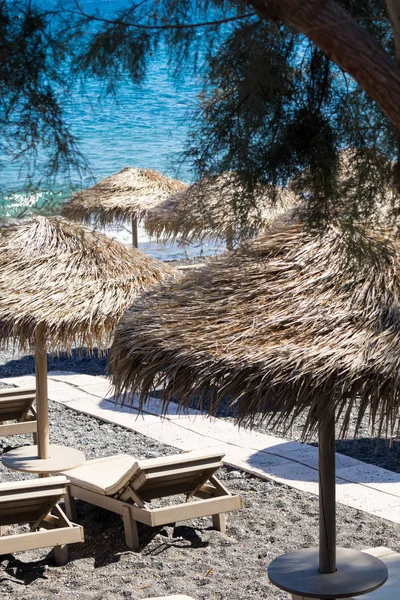 Strand mit Sonnenschirmen und Liegestühlen am Meer in Santorini — Stockfoto