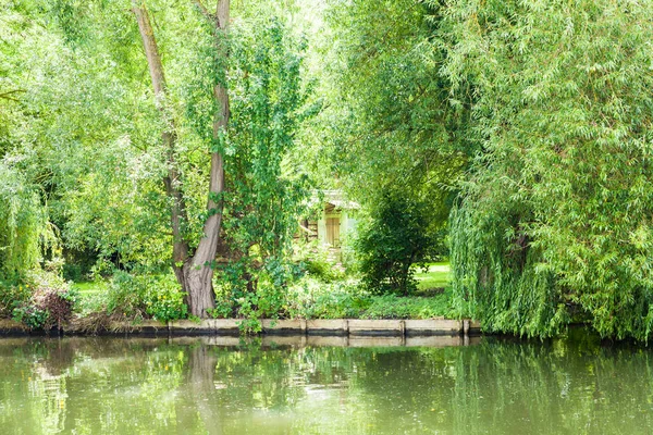 Casa Escondida Vegetación Árboles Flores Borde Canal Verano —  Fotos de Stock