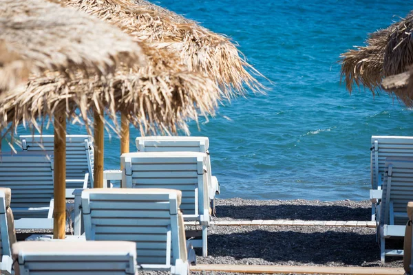 Playa con sombrillas y tumbonas junto al mar en Santorini — Foto de Stock