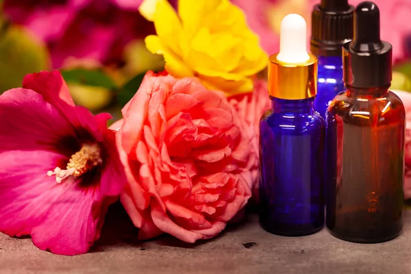 Flores y frascos de aceites esenciales para aromaterapia — Foto de Stock