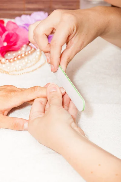 The beautician polish the client's nails before putting nail pol — Stock Photo, Image