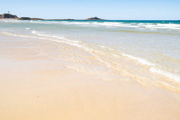 Large sandy beach in the town of "Sables d'or les pins" in Brittany at low tide in summer.