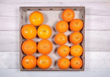 Mandalinalar ve mandalinalar eski ahşap zemin üzerinde eski bir ahşap tepside