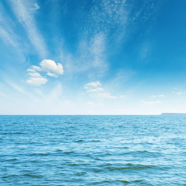 Mavi deniz ve beyaz bulutlar üzerlerinde