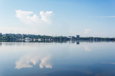 Bulutlu mavi gökyüzü ve yansımalı nehir.