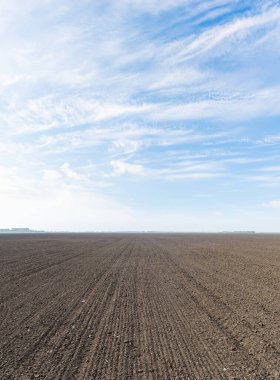 siyah tarım alanı ve bulutlu mavi gökyüzü