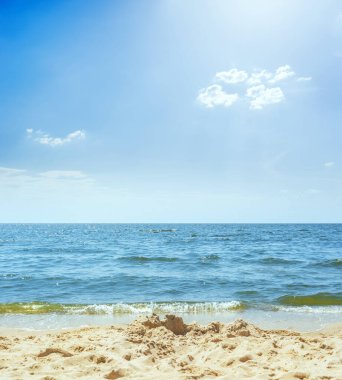 Deniz, kum ve bulutlu mavi gökyüzü