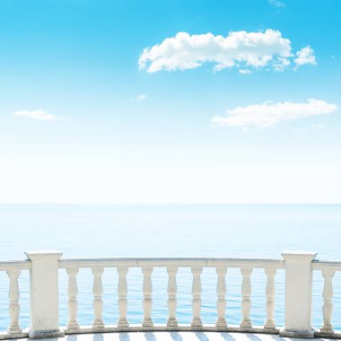 Denizin üzerinde balkon ve mavi gökyüzünde beyaz bulutlar