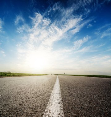 Asfalt yolda gün batımı masmavi gökyüzünde