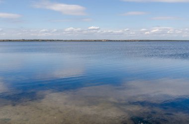 Gökteki alçak bulutlar ve nehirdeki yansımalar