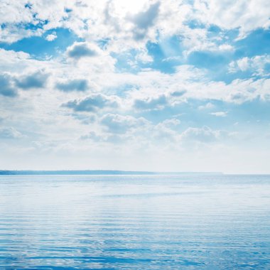 Dalgalarla su üzerinde düşük dramatik bulutlar