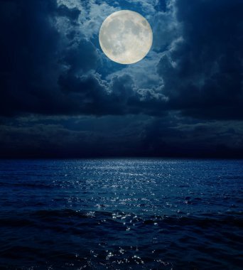 Denizin üzerindeki kara bulutlarda süper ay