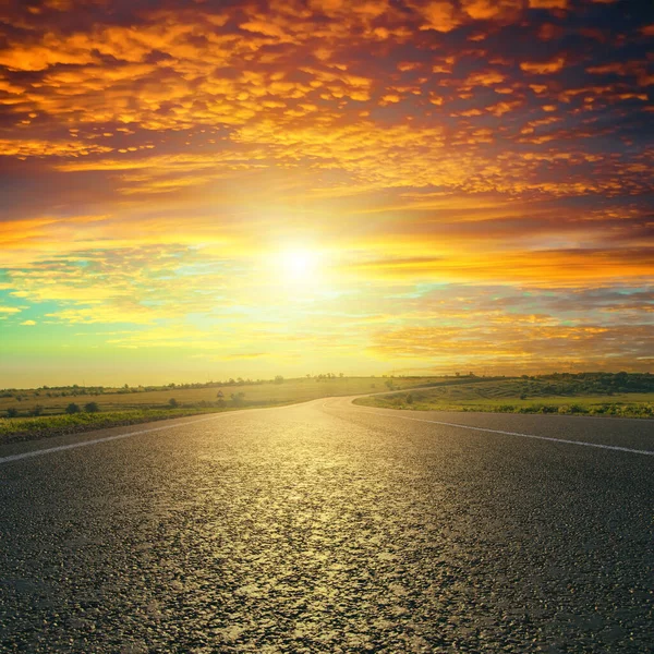 アスファルト道路上の赤い夕日 — ストック写真