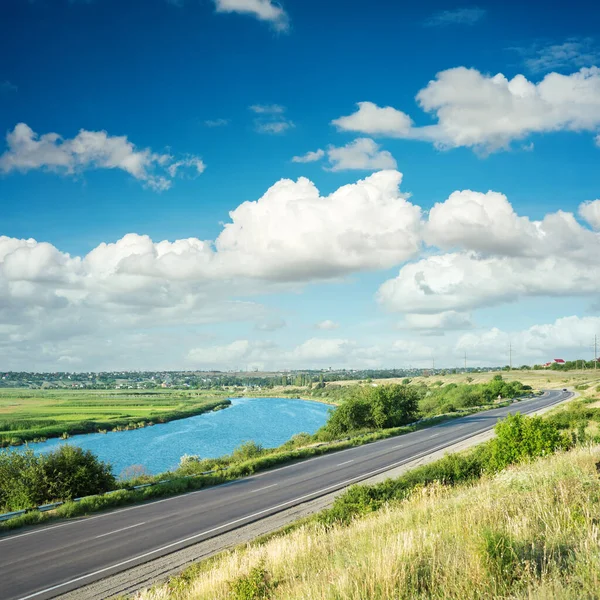 Dramatische Wolken Über Fluss Und Asphaltstraße — Stockfoto