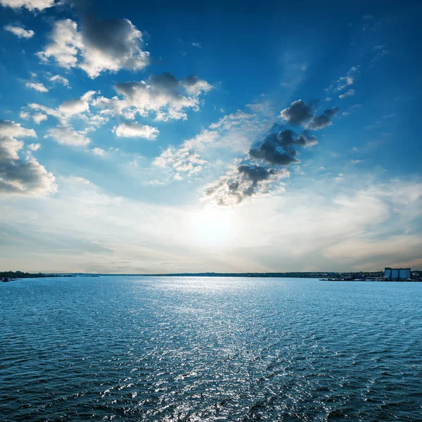 Sol Baixo Céu Azul Com Nuvens Sobre Água Escura — Fotografia de Stock