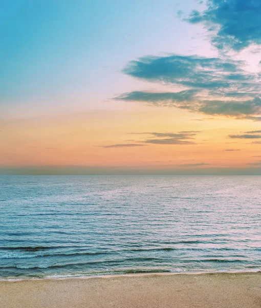 海と砂浜の上に雲があるいいオレンジの夕日 — ストック写真