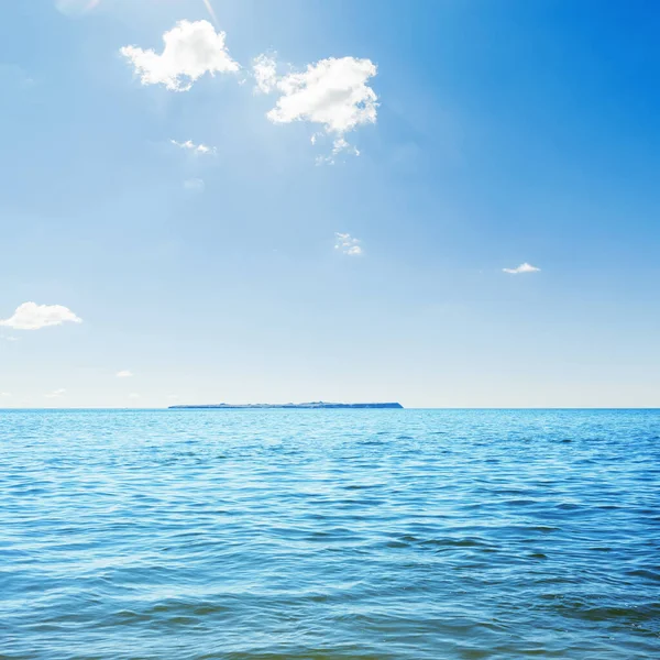 蓝色的海和乌云笼罩着它 地平线上的岛屿 — 图库照片