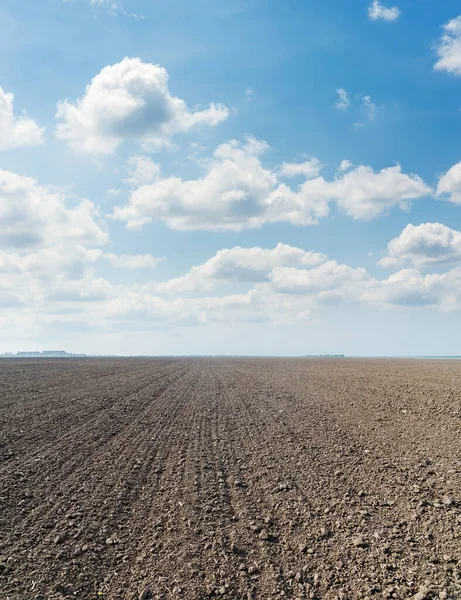 青い空に黒い農業が畑と雲を耕し — ストック写真