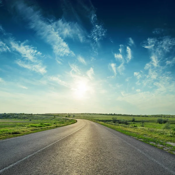 Asfalt yolda gün batımı masmavi gökyüzünde