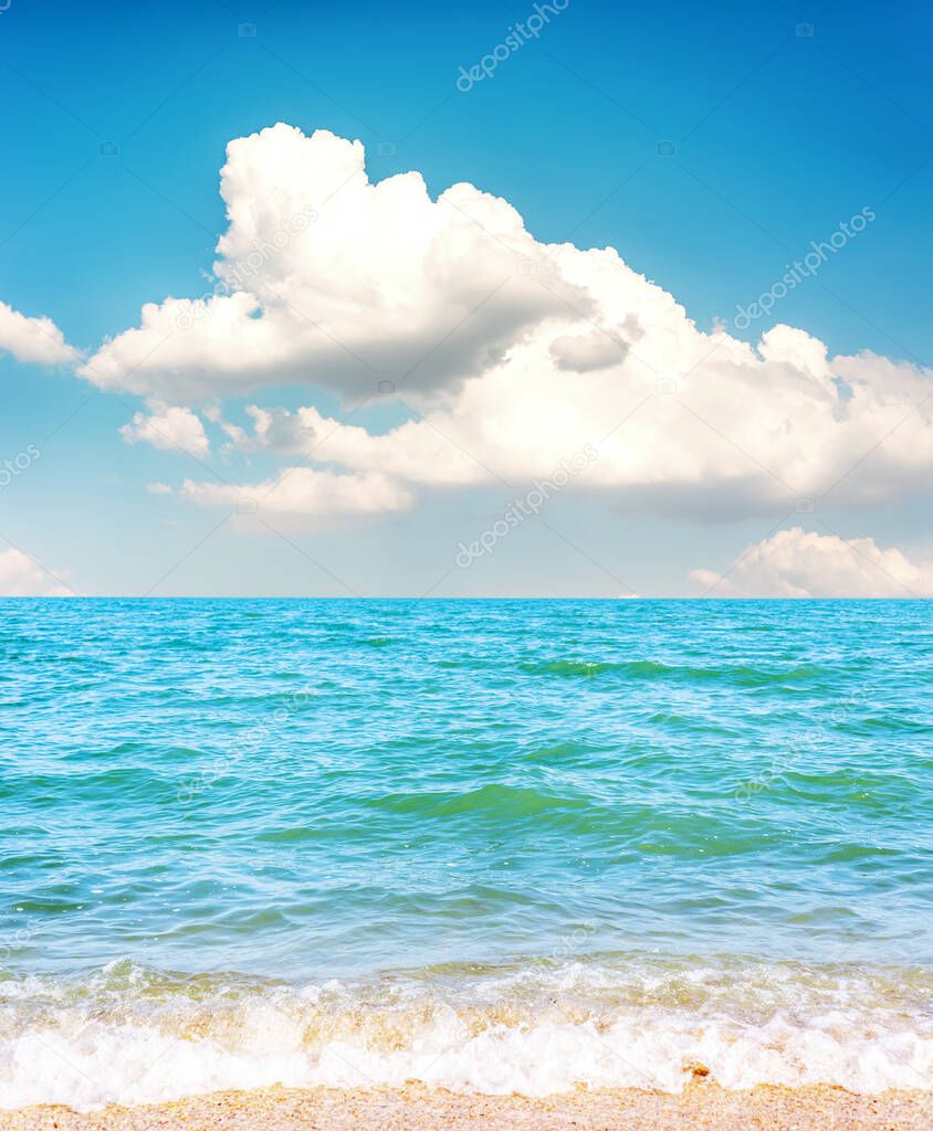 low clouds in blue sky over sea and sand beach