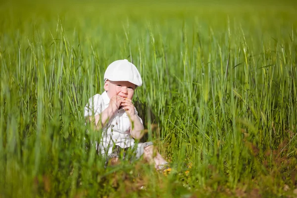Смішний Маленький Хлопчик Білій Шапці Відпочиває Зеленій Траві Літньому Парку — стокове фото