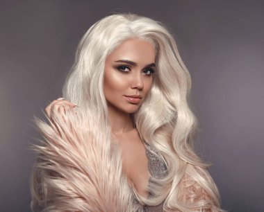 Yüksek moda kış stil. Faux kürk paltolu güzel sarışın kadın. Portre, Genç seksi sarışın modeli ile güzellik makyaj, uzun beyaz saç stili, poz gri studio arka plan üzerinde izole. 