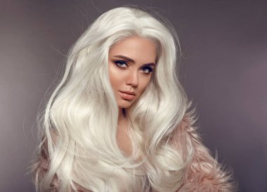 Faux kürk paltolu güzel sarışın kadın. Portre, Genç seksi sarışın modeli ile güzellik makyaj, uzun beyaz saç stili, poz gri studio arka plan üzerinde izole. Yüksek moda kış Style.