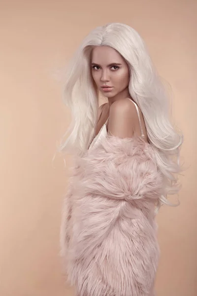 여자입니다 베이지색 스튜디오 배경에 분홍색 코트를 머리와 — 스톡 사진