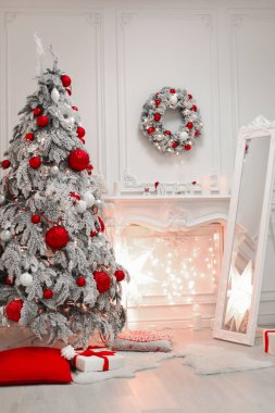 Noel iç ve dekorasyonlar. Karlı ağaç kırmızı hediye topları tatil kış modern oda dekore edilmiştir. Kartpostal sezon kış arka plan.