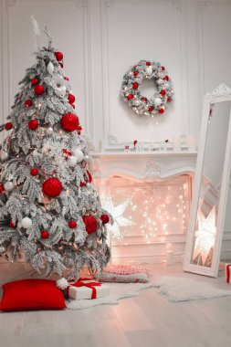 Noel iç ve dekorasyonlar. Karlı ağaç kırmızı hediye topları tatil kış modern oda dekore edilmiştir. Kartpostal sezon kış arka plan.