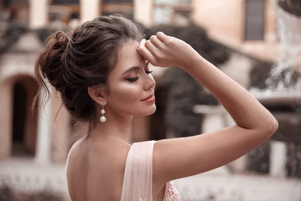 Krásná nevěsta s perličními náušnicemi šperky na růžových dres — Stock fotografie