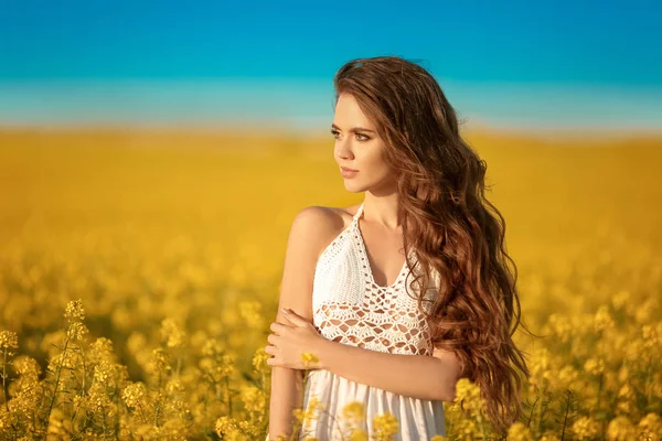 Όμορφο ανέμελη κορίτσι με μακρά σγουρά υγιή μαλλιά πάνω από το κίτρινο — Φωτογραφία Αρχείου