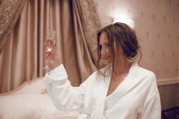 ¡Salud! Hermosa mujer morena en bata de baño blanca disfrutando de gla — Foto de Stock
